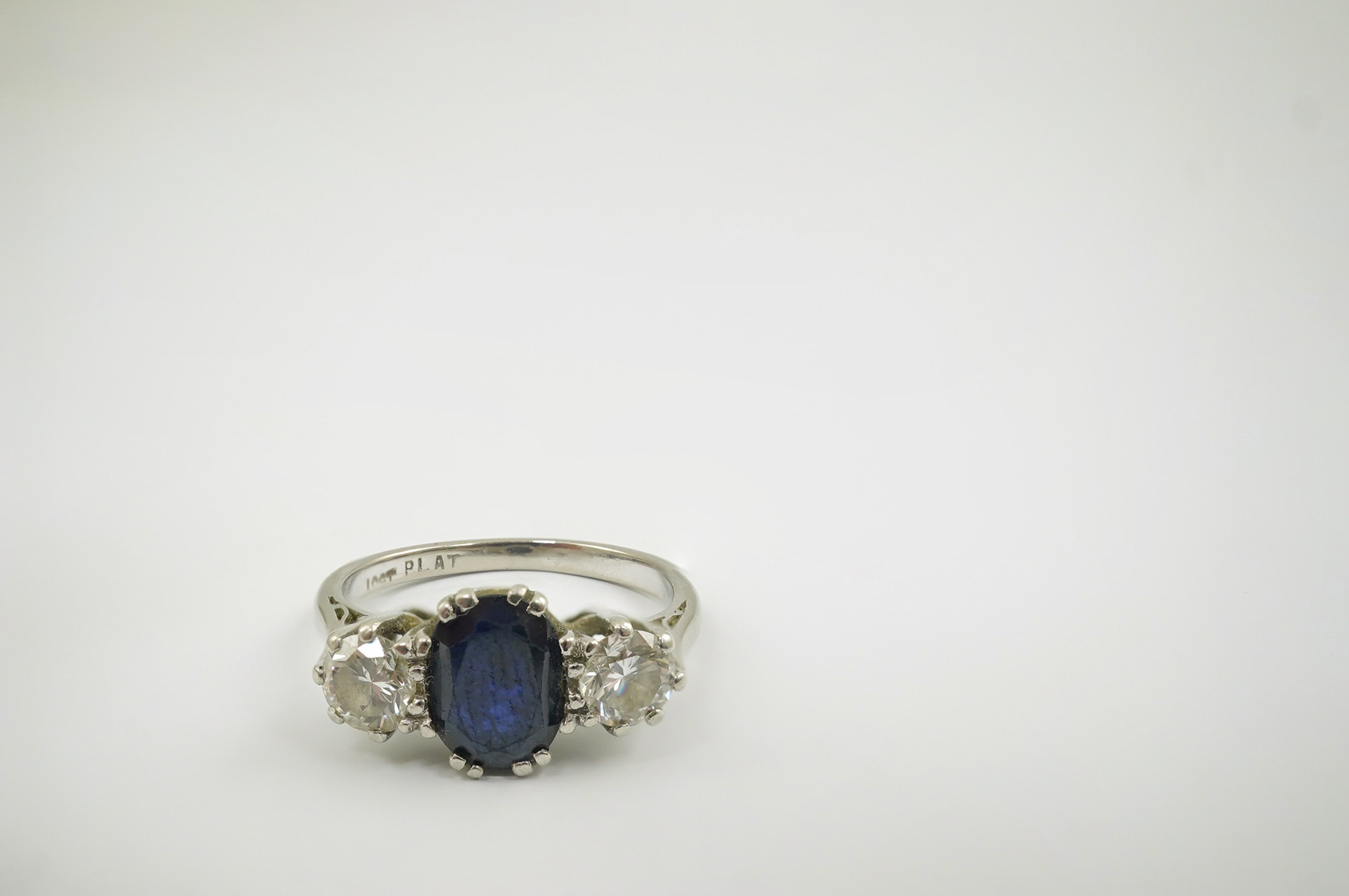 An 18ct white gold and platinum, single stone oval cut sapphire and two stone round cut diamond set ring, size J/K, gross weight 4 grams. Condition - fair